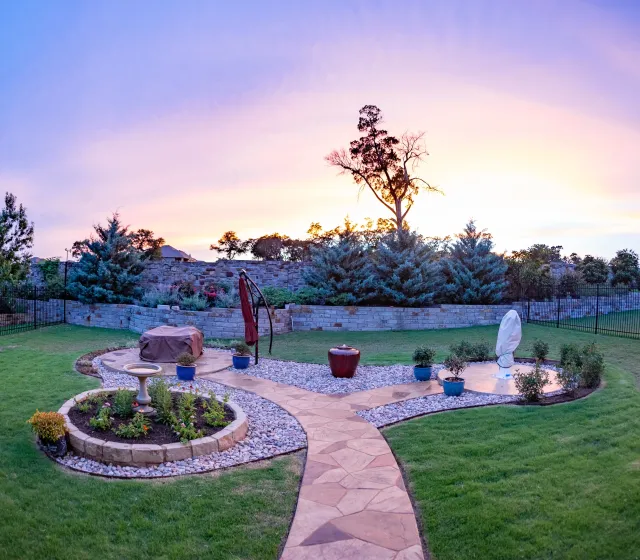 Custom Austin backyard landscape design with curved planting beds and pathways