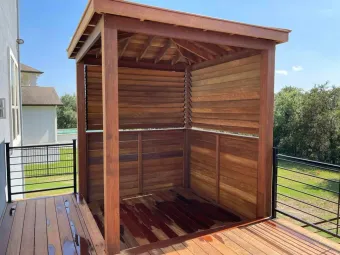 Louvered cedar pergola cabana built on a wood deck in an Austin backyard