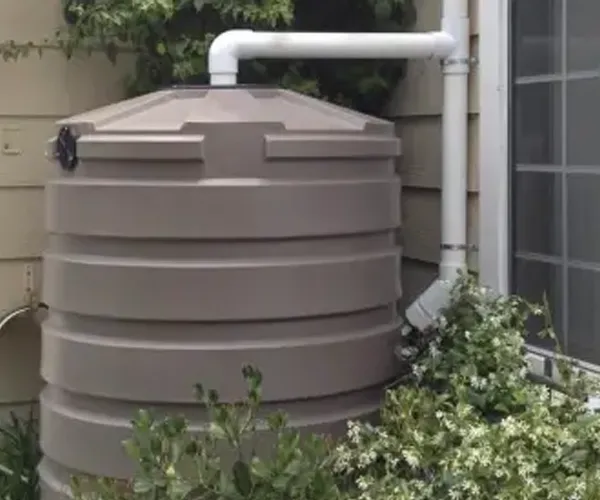 Rainwater storage tank connected to a downspout at an Austin home