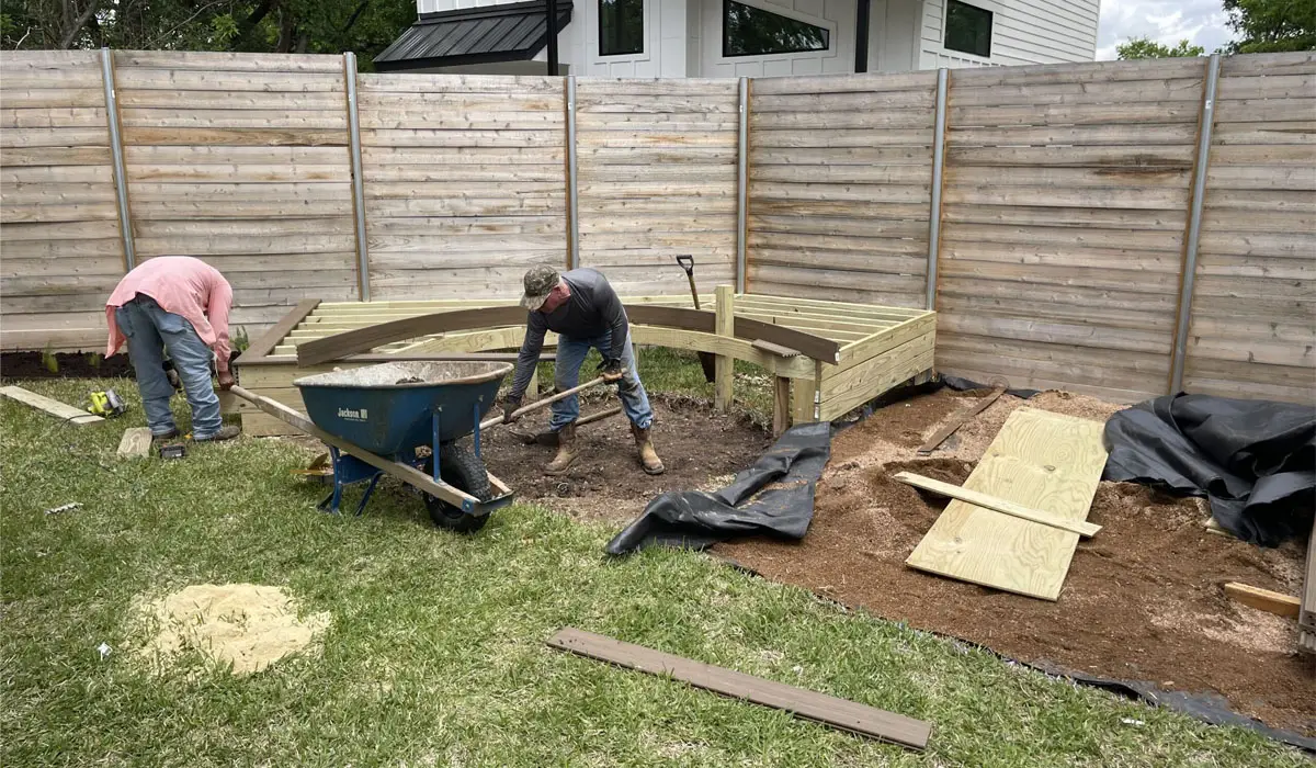 Two men working on backyard landscaping. Find best landscapers for residential areas.