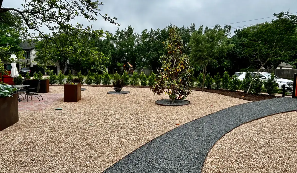 Aerial view of a professionally designed backyard landscape with plants, stone path, and garden beds.