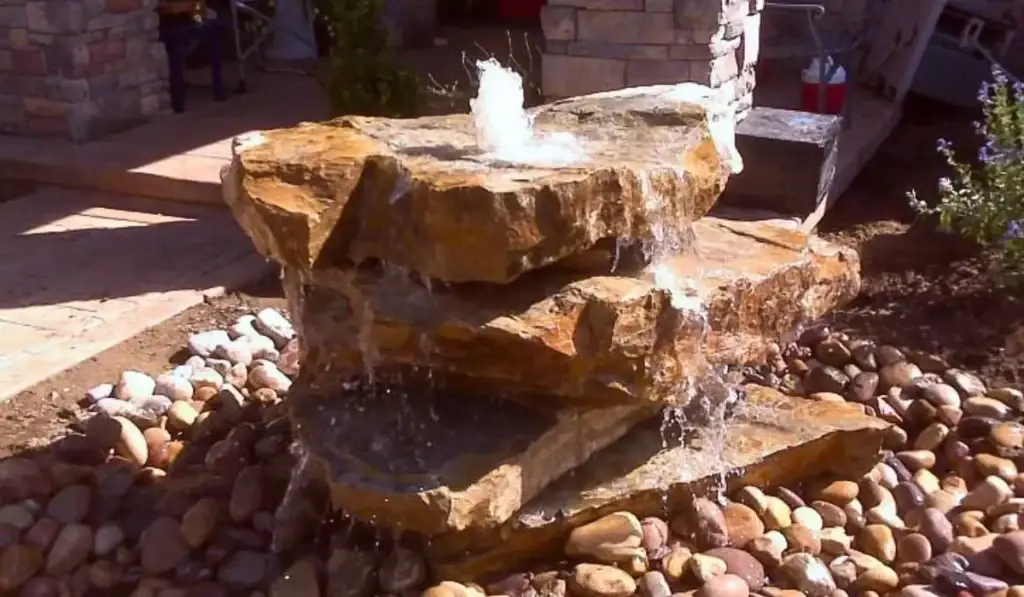 Stone custom water features with fountain design for small backyard outdoor landscape.