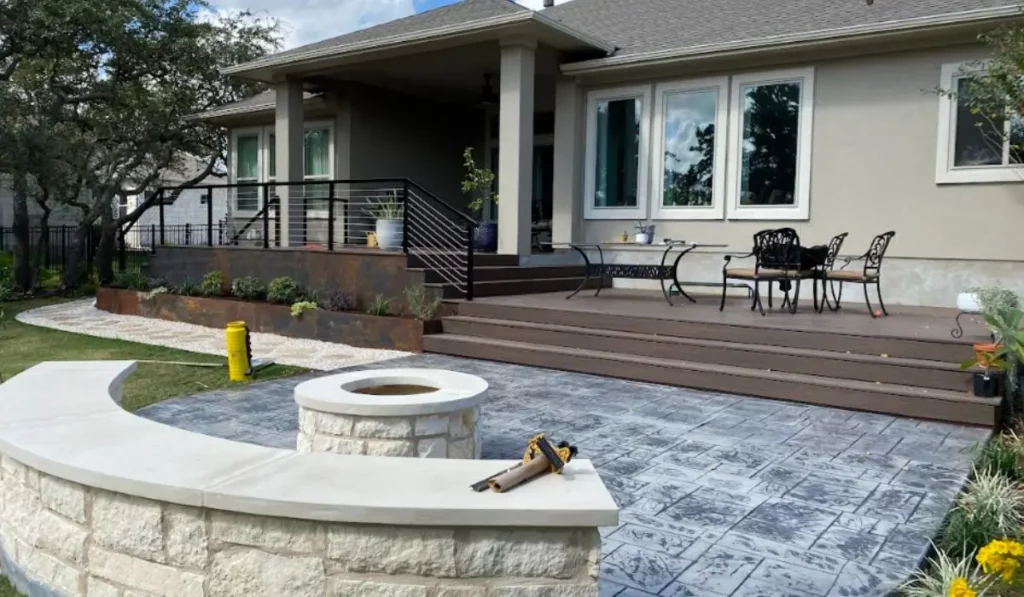 Backyard with custom stone fire pit landscaping, modern patio seating, and tiered planters enhancing outdoor comfort.