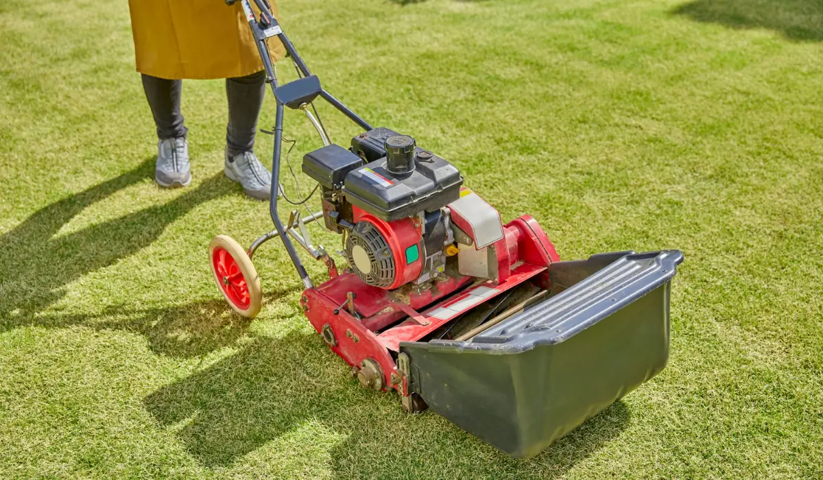 Autumn Lawn Care in Austin showing a core aerator machine being used on grass to relieve soil compaction and improve growth.
