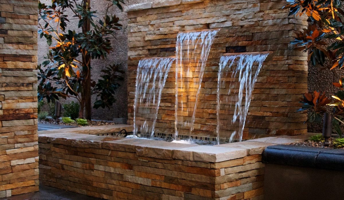 Elegant custom water features with cascading waterfalls enhance backyard ambiance and elevate outdoor living in Austin.